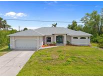 Charming single-story home with a well-manicured lawn, attached garage, and a welcoming blue front door at 13235 Essman Ave, Port Charlotte, FL 33953