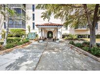 Inviting covered building entrance with landscaped surroundings and lovely plantings at 25188 Marion Ave # A206, Punta Gorda, FL 33950