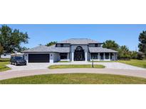 Stunning contemporary home with a grand entrance, circular driveway, and manicured lawn at 384 Viedma St, Punta Gorda, FL 33983