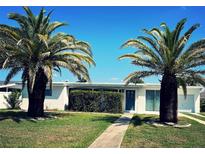Charming single-story home with lush lawn, vibrant palm trees, and a welcoming entrance at 535 Lindley Ter, Port Charlotte, FL 33952