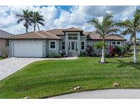 Beautiful single-story home features a tile roof, front lawn, driveway, landscaping, and an attached garage at 571 Port Bendres Dr, Punta Gorda, FL 33950