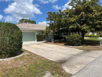 Charming single-story home features a well-maintained lawn, mature trees, and a paved driveway at 931 Juno Dr, Punta Gorda, FL 33950