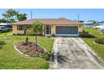 Charming single-story home featuring a well-manicured lawn, lovely stone accents, and a spacious driveway at 167 N Cambridge Nw Dr, Port Charlotte, FL 33952