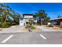 Contemporary two-story home featuring a unique architectural design with a garage and well-kept yard at 1851 Scenic Dr, Venice, FL 34293