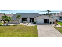 Charming single-story home with manicured lawn, stone accents, and a two-car garage at 25319 Vantage Ln, Punta Gorda, FL 33983
