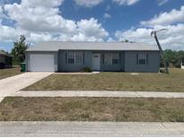 Charming single-story home with a well-maintained lawn, gray exterior and a one car garage at 6728 Thorman Rd, Port Charlotte, FL 33981