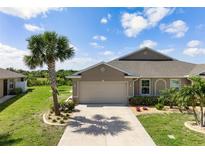Charming single-Gathering home featuring a two-car garage, lush landscaping, and a well-maintained lawn at 7209 W Lenox Cir, Punta Gorda, FL 33950