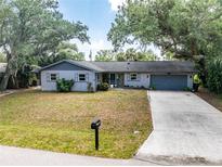 Charming single-story home with a well-maintained lawn and mature shade trees at 1173 Belmar Ave, Port Charlotte, FL 33948
