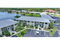 An exterior view of a condo building with balconies, green landscaping and parking at 25225 Rampart Blvd # 1607, Punta Gorda, FL 33983