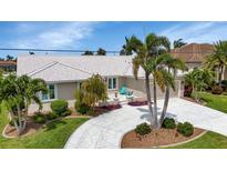 Beautifully landscaped front yard features a unique driveway and tropical foliage at 859 Napoli Ln, Punta Gorda, FL 33950