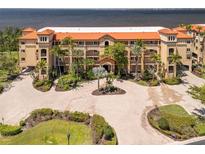 Beautiful waterfront condo building with lush landscaping and a circular brick paved driveway at 93 Vivante Blvd # 9344, Punta Gorda, FL 33950