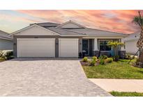 Charming single-Gathering home boasting a brick driveway and a two-car garage, complemented by a well-manicured lawn at 12857 Pinnacle Ln, Venice, FL 34293