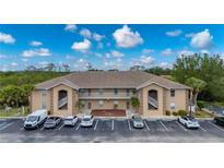 Exterior view of condo building with beige paint, covered stairwells, second story balconies and parking at 175 Kings Hwy # B2 1522, Punta Gorda, FL 33983