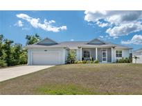 Charming single-story home featuring a two-car garage, covered porch, and well-maintained lawn at 2229 Wakefield St, Port Charlotte, FL 33948