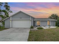 Single-story home boasts a large garage door, well-maintained lawn, and welcoming curb appeal at 242 Seminole Nw Blvd, Port Charlotte, FL 33952