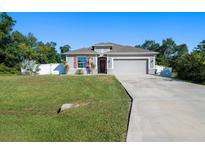 Charming single-story home boasts a well-manicured lawn, two car garage, and inviting curb appeal at 3476 Brewster Rd, North Port, FL 34288