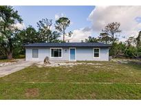 Charming single-story home featuring a well-manicured lawn and a bright blue front door at 6329 David Blvd, Port Charlotte, FL 33981