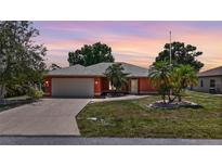 Charming single-story home with a two car garage and tropical landscaping at 23331 Billings Ave, Port Charlotte, FL 33954