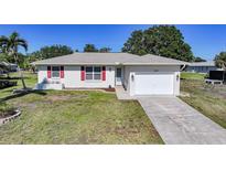 Charming single-story home with a well-manicured lawn and a convenient attached two-car garage at 2621 Larkspur Dr, Punta Gorda, FL 33950