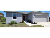 Charming home with a two-car garage, walkway to front door, window and beautiful landscaping at 26456 View Dr, Punta Gorda, FL 33983