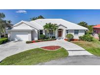 Inviting single-story home with a well-manicured lawn, elegant landscaping, and a pristine white tile roof at 3513 Dileuca St, Punta Gorda, FL 33950