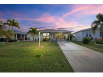 Charming single-story home with well-maintained lawn, palm trees, and a long driveway at 3520 Kenneth Rd, Port Charlotte, FL 33953