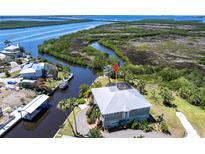 Stunning aerial view of waterfront home, lush landscaping, private dock, and picturesque river access at 3712 Balboa Ct, Punta Gorda, FL 33983