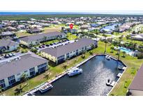 Scenic aerial view of condos with boat docks, a pool and lush landscaping near the water at 4000 Bal Harbor Blvd # 124, Punta Gorda, FL 33950