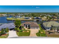 Stunning waterfront property showcasing lush greenery, a boat dock, and a beautiful neighborhood setting at 4174 Perch Cir, Port Charlotte, FL 33948