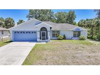 Charming single-story home with a blue garage door, screened porch, and well-maintained front yard at 5640 Burdette Ter, North Port, FL 34287