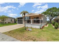 Charming home with a screened-in porch, covered deck and manicured lawn with mature trees at 714 Fairmount Dr, North Port, FL 34287