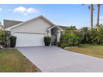 Charming single-story home with attached garage and tropical landscaping at 719 Ellicott Nw Cir, Port Charlotte, FL 33952