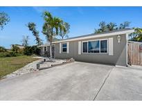 Charming single-story home featuring a spacious driveway and a well-maintained lawn with a young palm tree at 1249 Indus Rd, Venice, FL 34293