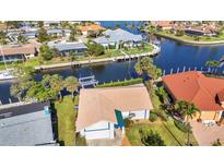 Aerial shot showcases the waterfront property with lush landscaping, and its private boat dock on the canal at 125 Donna Ct, Punta Gorda, FL 33950