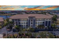 Elegant condominium building featuring multiple stories and picturesque balconies overlooking lush landscaping at 1349 Aqui Esta Dr # 121, Punta Gorda, FL 33950