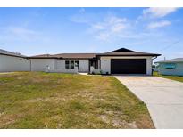 Charming single-story home featuring a dark brown roof and garage door with a well-maintained lawn at 3315 Elkcam Blvd, Port Charlotte, FL 33952