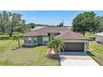 Inviting single-story home showcasing a well-manicured lawn and charming front yard landscaping at 347 Casale G St, Punta Gorda, FL 33983