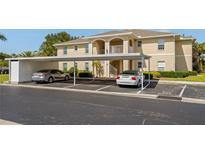 View of parking under the building with two cars parked in the shade at 5800 Sabal Trace Dr # 1302, North Port, FL 34287