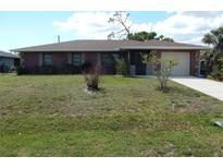 Charming single-story home featuring an attached garage and well-maintained front yard at 582 Reading Nw St, Port Charlotte, FL 33952
