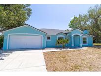 Charming single-story home with a two-car garage and light blue exterior paint at 6308 Grove Blvd, Punta Gorda, FL 33982