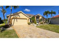 Beautiful single-story home featuring a well-manicured lawn, concrete driveway, and tan-colored paint at 10203 Windsong Rd, Punta Gorda, FL 33955
