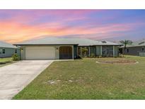 Charming single-story home with a well-manicured lawn and a two-car garage at 1069 Fergus Ln, Punta Gorda, FL 33983
