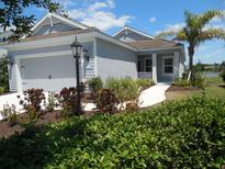 Charming single-story home with a manicured lawn, featuring a two-car garage and a welcoming front porch at 12656 Sagewood Dr, Venice, FL 34293