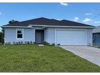 Charming single-story home with a manicured lawn and attached two-car garage at 198 Arch Dr, Rotonda West, FL 33947