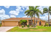 Charming single-story home with well-manicured lawn, tropical landscaping, and inviting double-door entry at 2202 Peterborough Rd, Punta Gorda, FL 33983