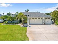 Charming single-story home with a three-car garage, lush landscaping, and a well-manicured lawn at 265 White Marsh Ln, Rotonda West, FL 33947