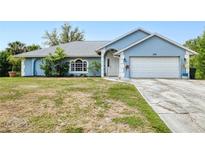 Charming, one story home with a white garage door, arched entry, and well-maintained lawn at 2685 Nanette Ln, North Port, FL 34286