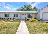 Charming single-story home boasts a tidy front yard and well-maintained landscaping with a concrete walkway to the front door at 4359 Pocatella Ave, North Port, FL 34287