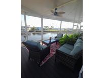 Comfortable outdoor screened patio with patio furniture, a ceiling fan, and relaxing waterfront views at 517 Clarion Pl, North Port, FL 34287