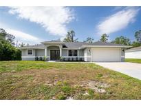 Charming single-story home features a two-car garage and neatly manicured lawn at 5611 Ganyard Ave, North Port, FL 34291